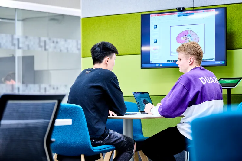 Two level three students examining brain image on large screen in Teaching and Learning Centre