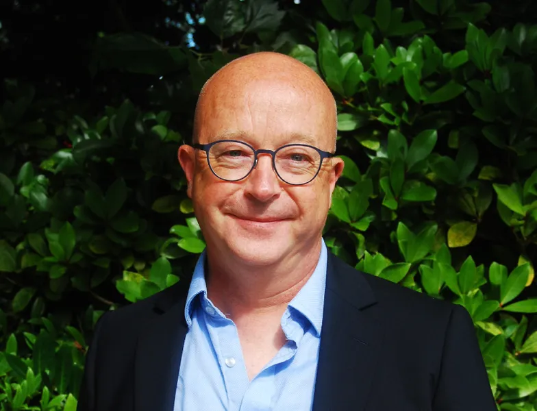 A bald man wearing glasses and a shirt with blazer
