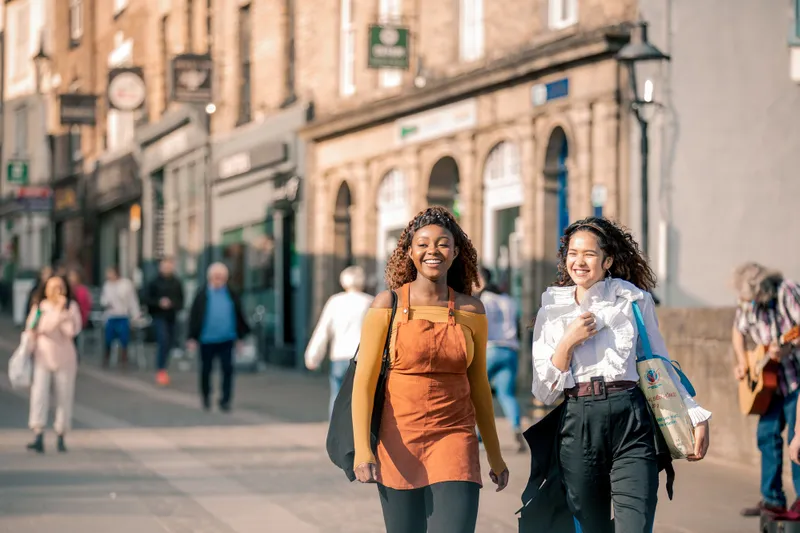 Two women in walking through Durham city centre
