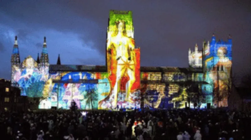 Durham Cathedral illuminated with art with crowds in the foreground
