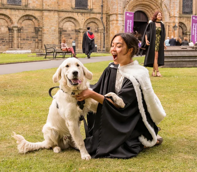 Graduate in robes with dog