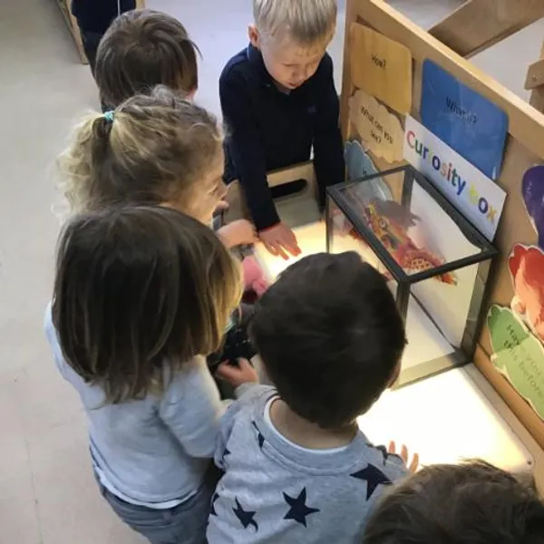 Children looking at paper Chinese dragon in a curiosity box