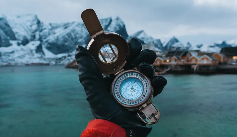 A hand holding a compass in Norway