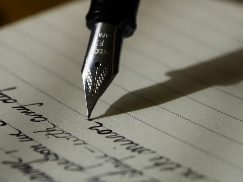 Close up image of a fountain pen writing on lined paper