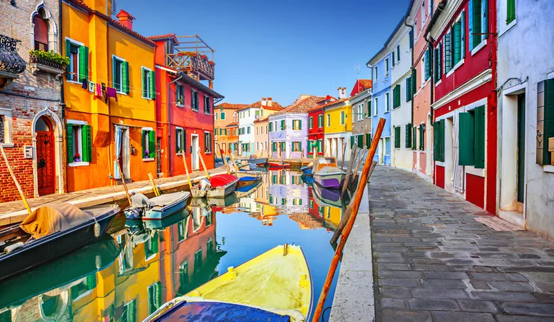 A canal in Burano, Italy lined with colourful buildings