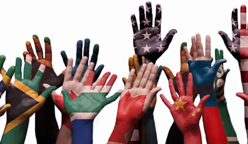Raised hands painted in the colours of flags from around the world