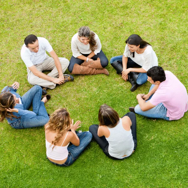 Group of friends sitting cross legged on the grass