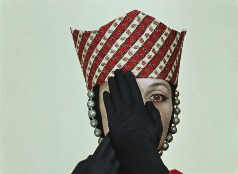 Woman with gloved hand in front of her face