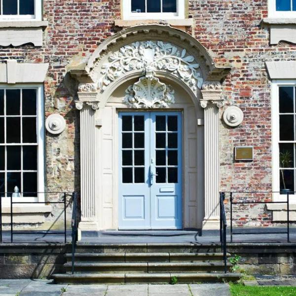 Old building with a pale blue door and steps