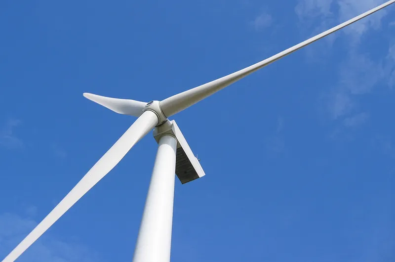 A wind turbine against a clear blue sky