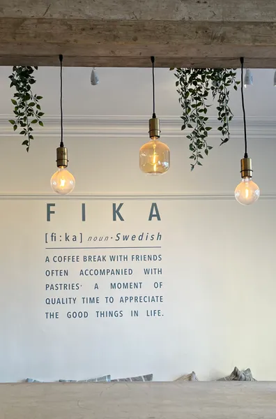 A definition of Fika written on a cream wall in blue text