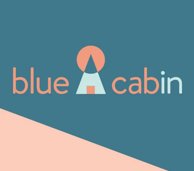 logo of 'blue cabin', with a tepee made out of basic shapes in between the words. The text 'in' in 'cabin' is in light blue.