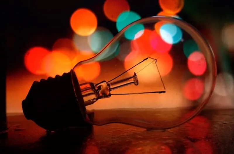 light bulb silhouetted by fairy lights