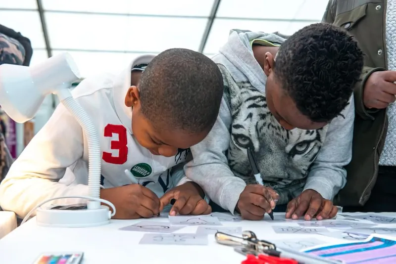 Two children drawing during an outreach session