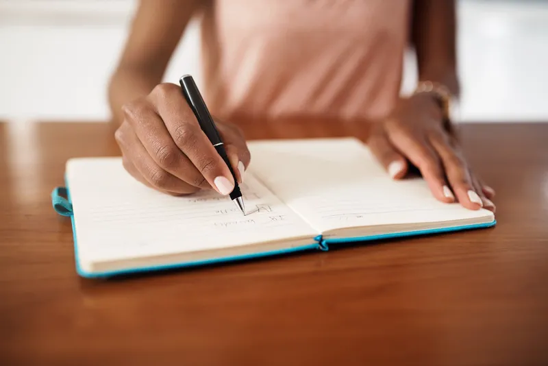 A women writing on a notebook