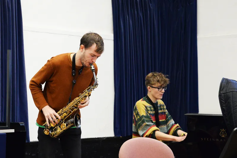 Student playing the saxophone accompanied by pianist