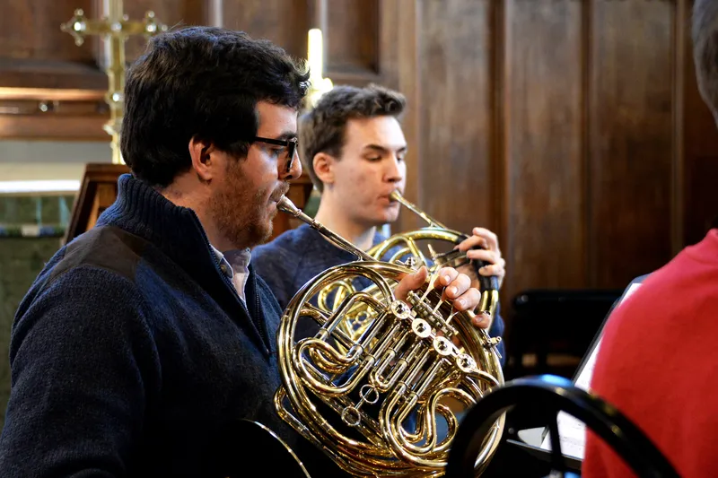 Two students playing the horn in Hatfield Chapel