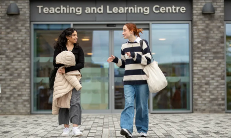 Two students walking and chatting outside the Teaching and Learning Centre