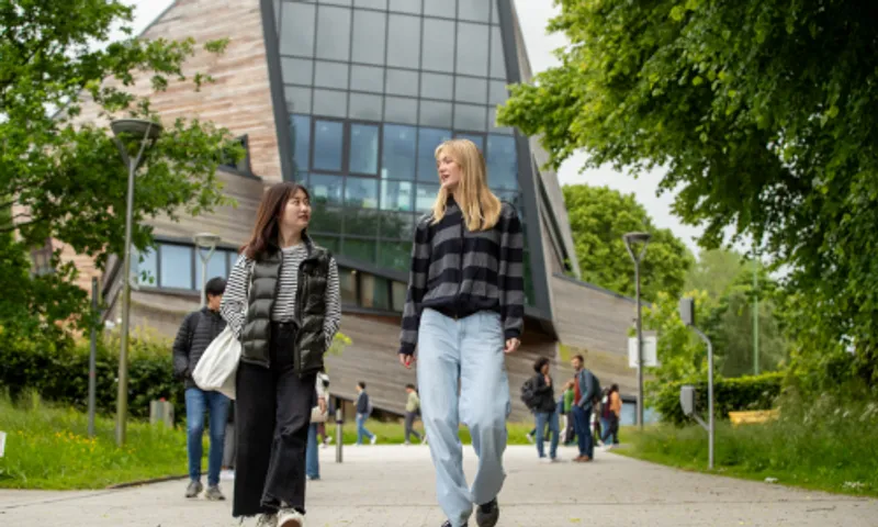 Two female students walking and chatting outside of the Ogden Centre