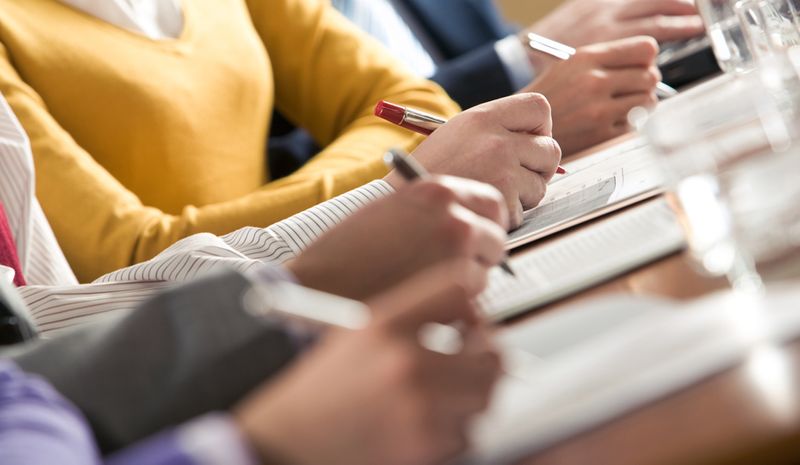 People taking notes during a business meeting