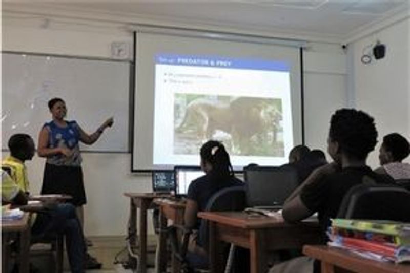 A teacher explaining a maths problem to a class of students in Africa