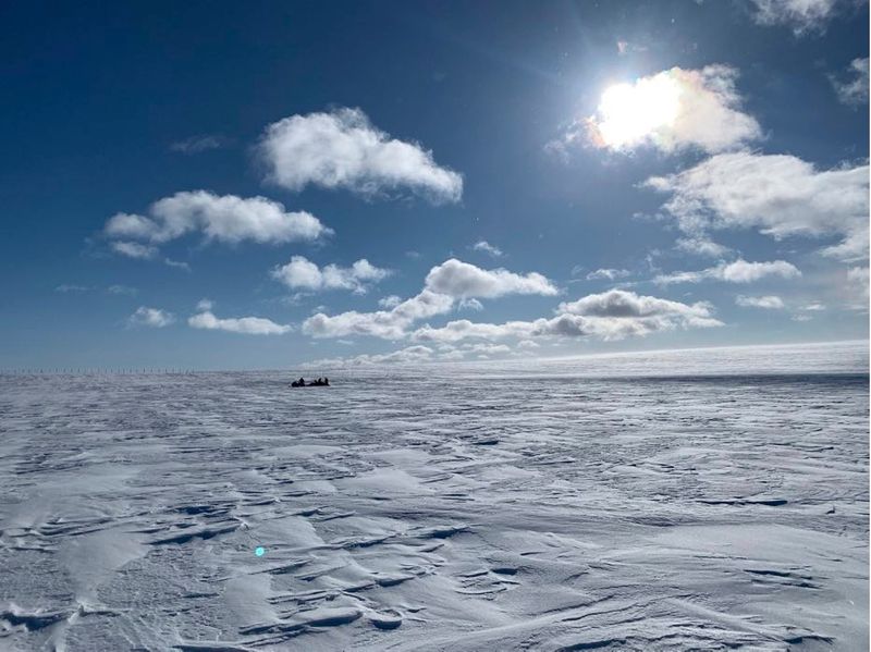 A snowmobile going across Arctic landscape