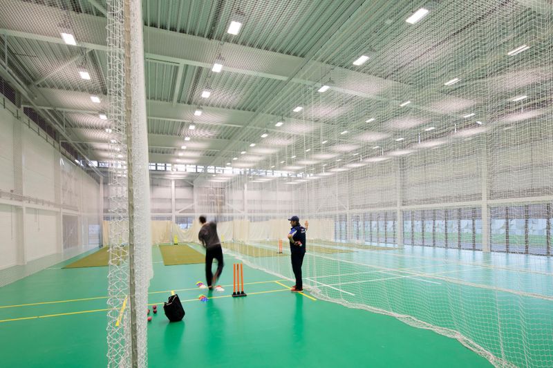A student practising cricket indoors