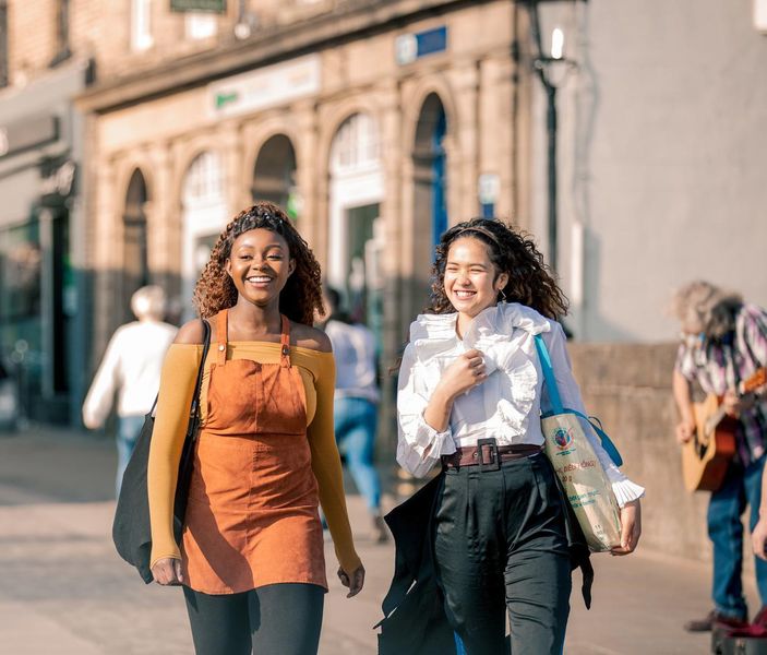 Two women in walking through Durham city centre