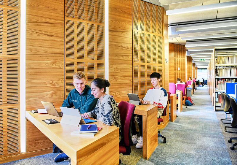 Students studying at desks inside the library