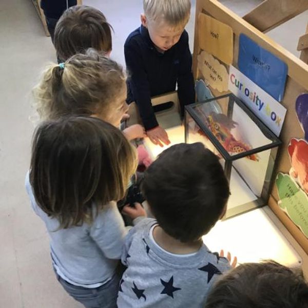 Children looking at paper Chinese dragon in a curiosity box