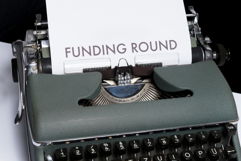 Typewriter with funding round on paper