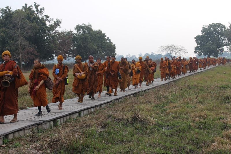 Buddhist pilgrims walking on raised walkway at Tilaurakot
