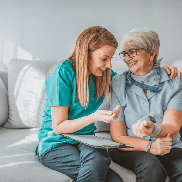 A young woman checking an older woman's blood pressure