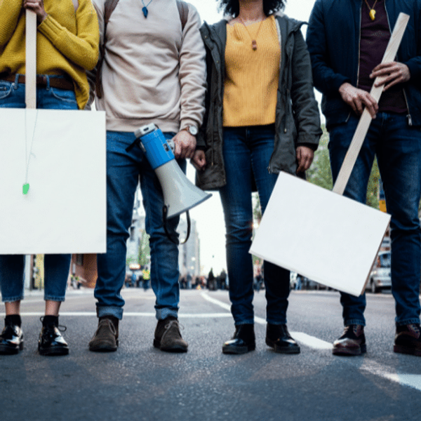 Four people at a protest holding boards
