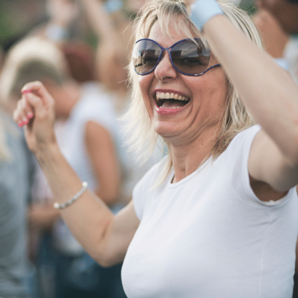 A woman in a white tee shirt dancing at a concert
