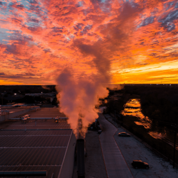Smoke and air pollution at sunset over buildings