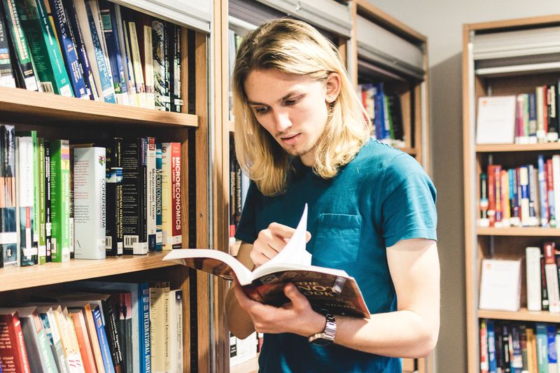 Student in library looking at book