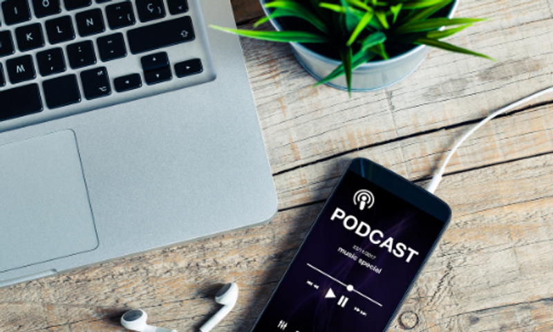 Laptop and phone playing a podcast