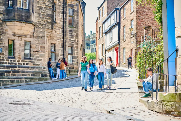 A group of students walking down a cobbled street in Durham