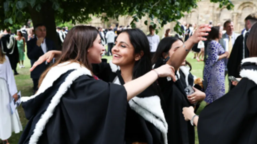 Two female graduates embracing at Graduation ceremony