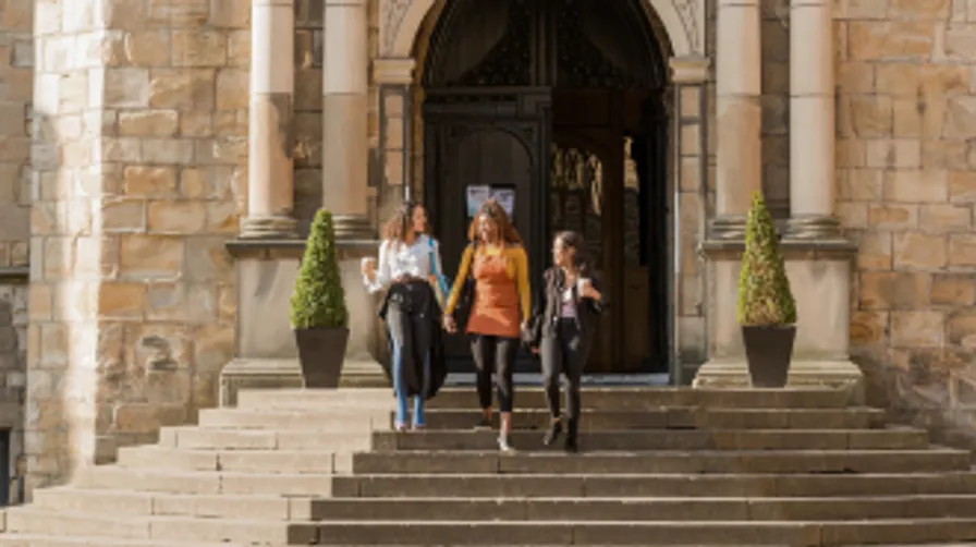 Three female students walking down the Castle stairs