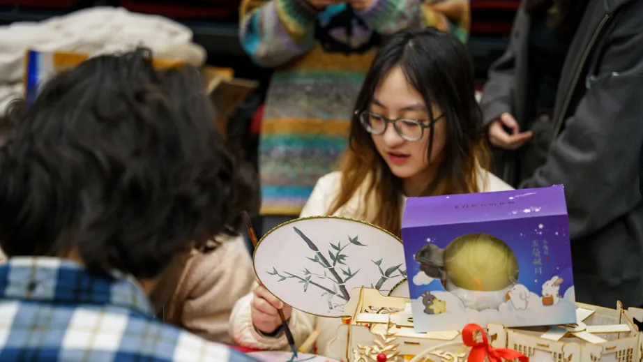 Students painting fans during a craft session at World Fest