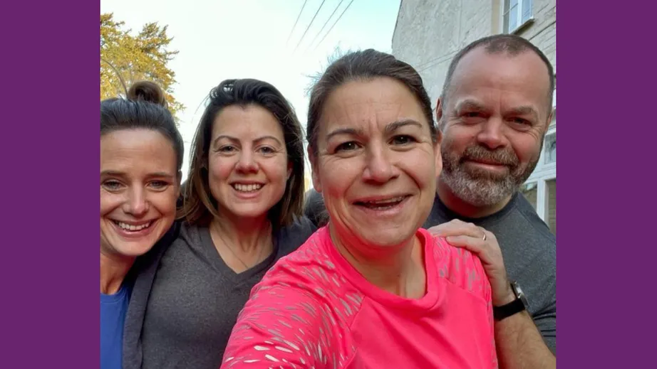 A group of three women and a man smiling at the camera