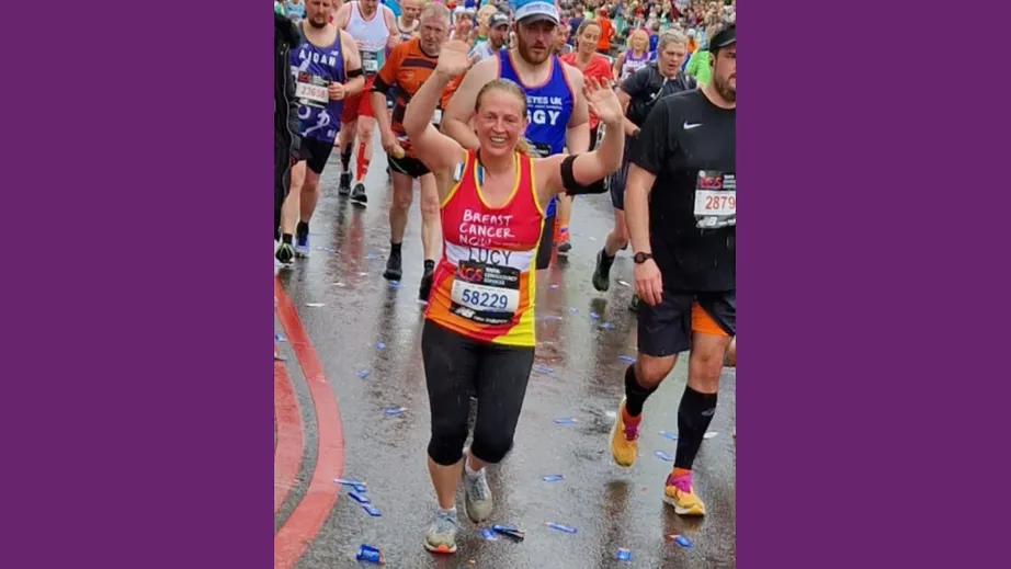 A woman running in a crowd whilst celebrating by throwing her arms in the air