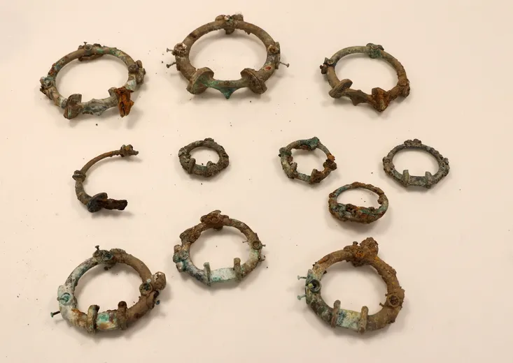 A group of metal rings of varying sizes, which have rusted and corroded in various places.
