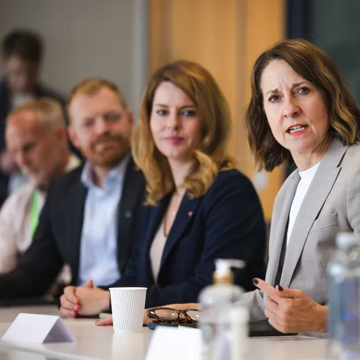 Men and women sitting at a desk having a business meeting