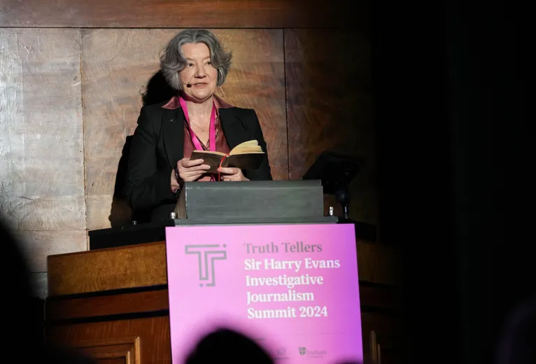 Woman standing behind lectern, giving speech