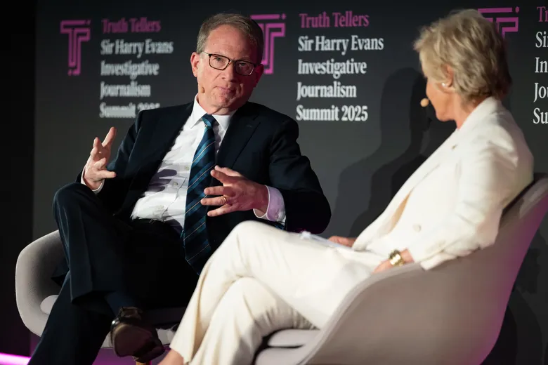Man and woman sitting on stage, in discussion