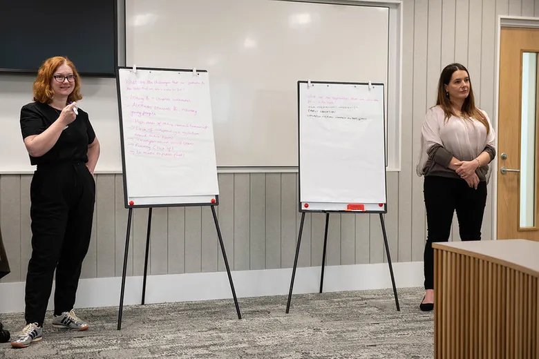 Two women standing with flipcharts