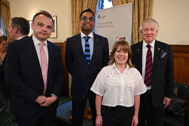 Three men and a woman standing in front of a pull-up banner